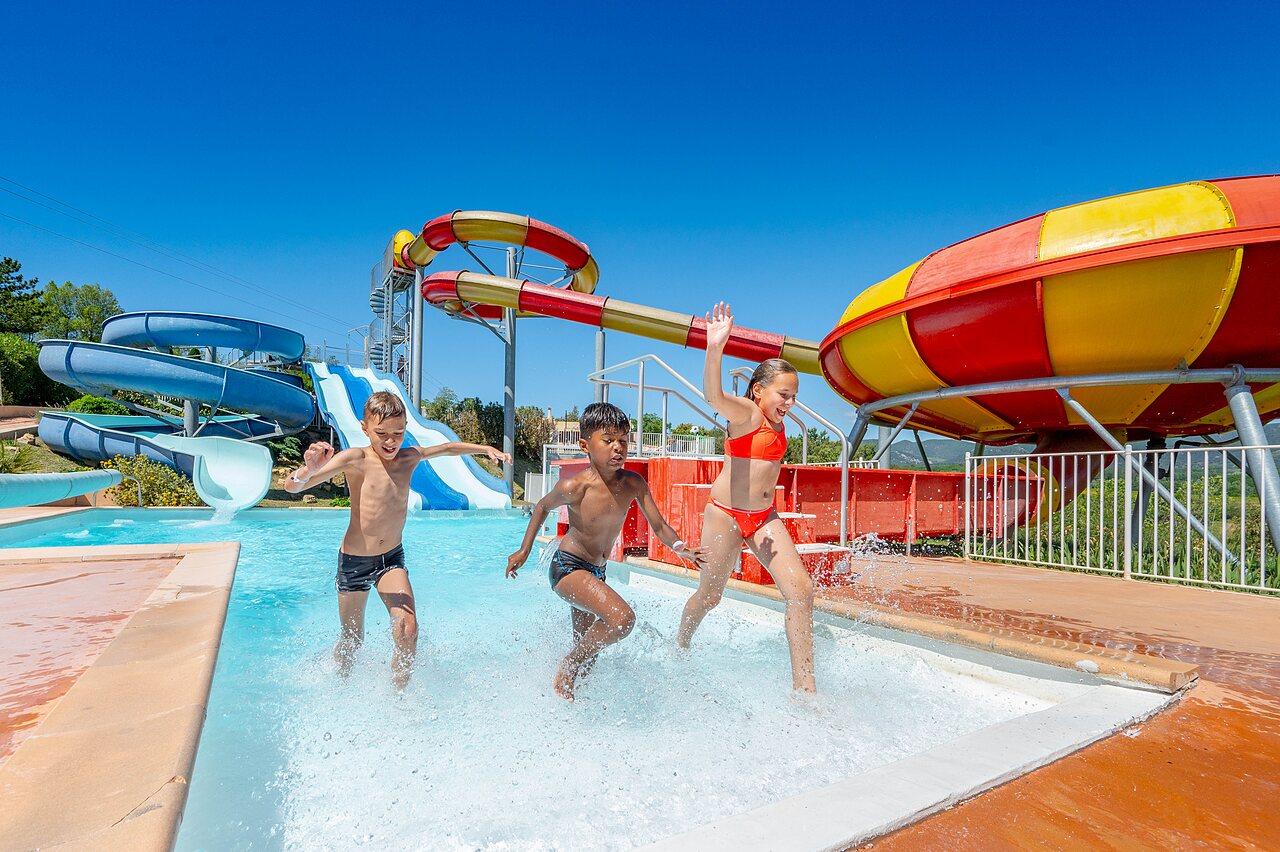 Kinderen spelen in zwembad met reuzenglijbanen op camping VAGUES OCEANES Soleil de Provence in Saint-Romain-en-Viennois.