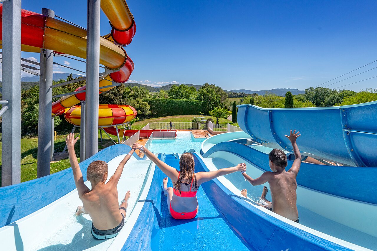 Kinderen op reusachtige waterglijbanen en zwembad op camping VAGUES OCEANES Soleil de Provence in Saint-Romain-en-Viennois (84).