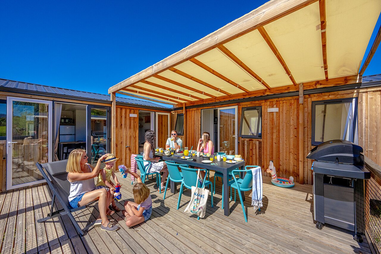 Stacaravan met overdekt terras en familiemaaltijd op camping VAGUES OCEANES Soleil de Provence in Saint-Romain-en-Viennois.