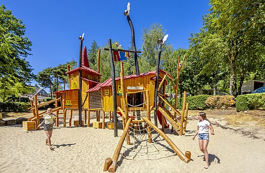 Grote houten speeltuin met hutten en glijbanen op camping CLICOCHIC Soleil Levant in Canet-de-Salars (12).