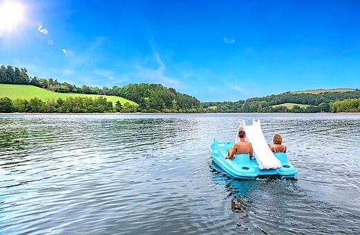Waterfiets met glijbaan op meer, stel op camping CLICOCHIC Soleil Levant.