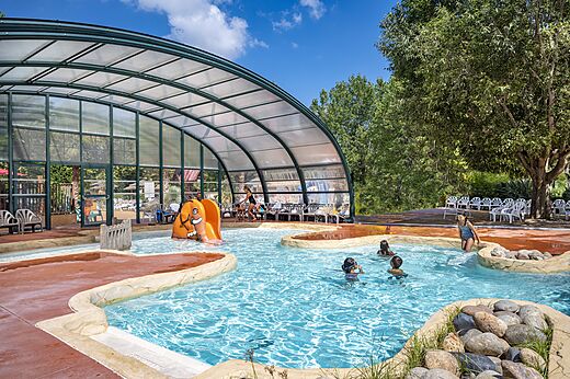 Buitenzwembad met olifantenglijbaan en kinderen, op camping CAPFUN Soubeyranne in REMOULINS (30).