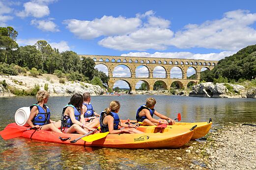 Familie in kajak op rivier met Romeins aquaduct bij camping CAPFUN Soubeyranne in REMOULINS (30).