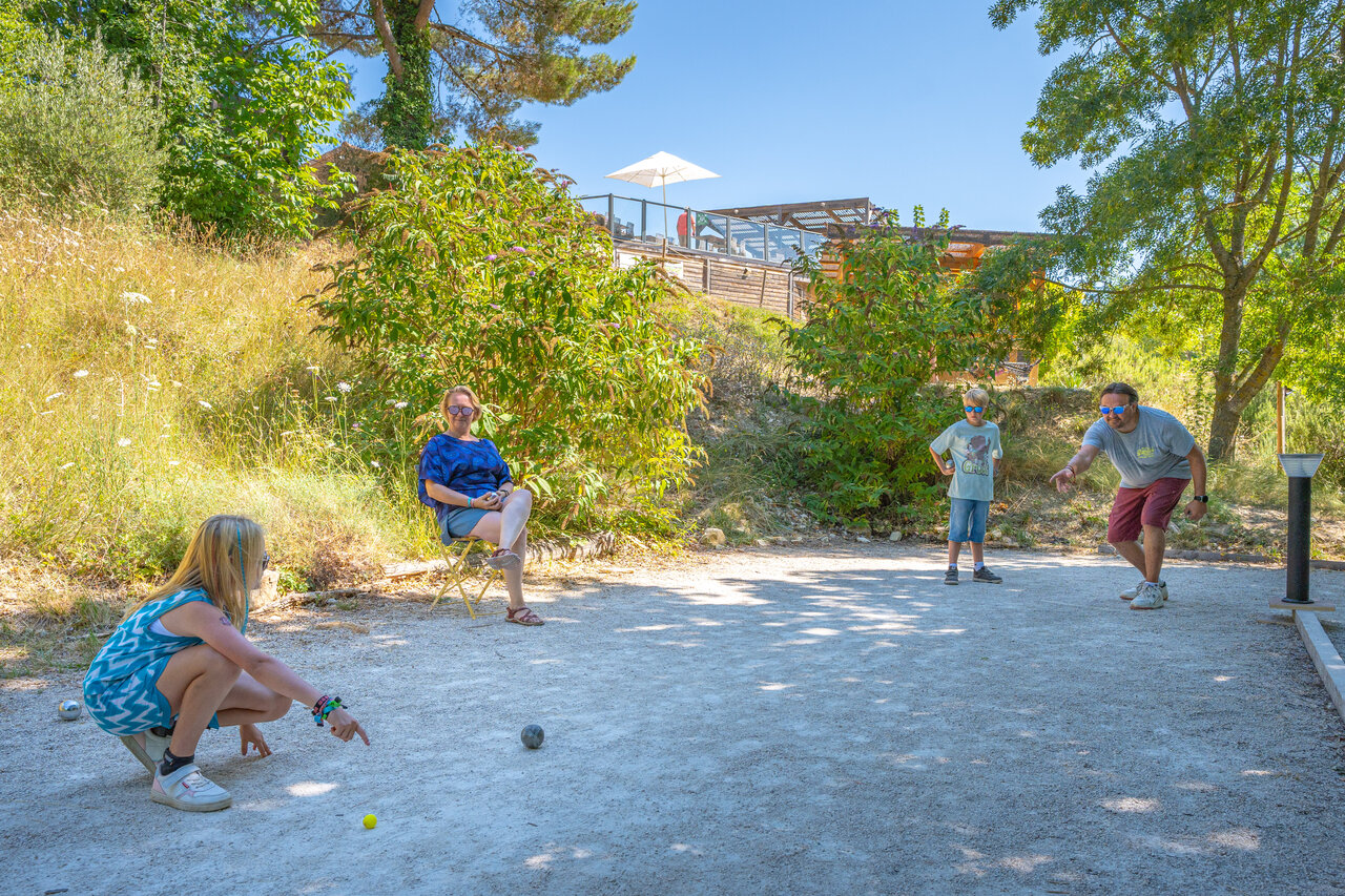 Familie speelt jeu de boules op terrein camping CLICOCHIC Source du Jabron.