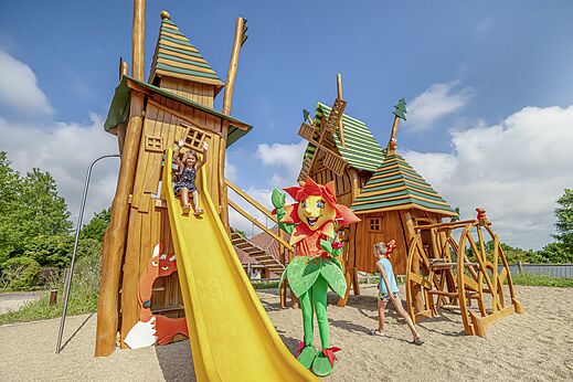 Houten speeltuin met glijbaan en kinderen op camping CLICOCHIC Source du Jabron in Comps (26)