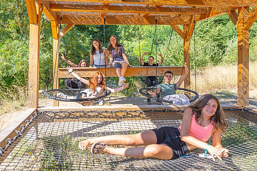 Jongeren vermaken zich op schommels en hangmat op camping CLICOCHIC Source du Jabron.