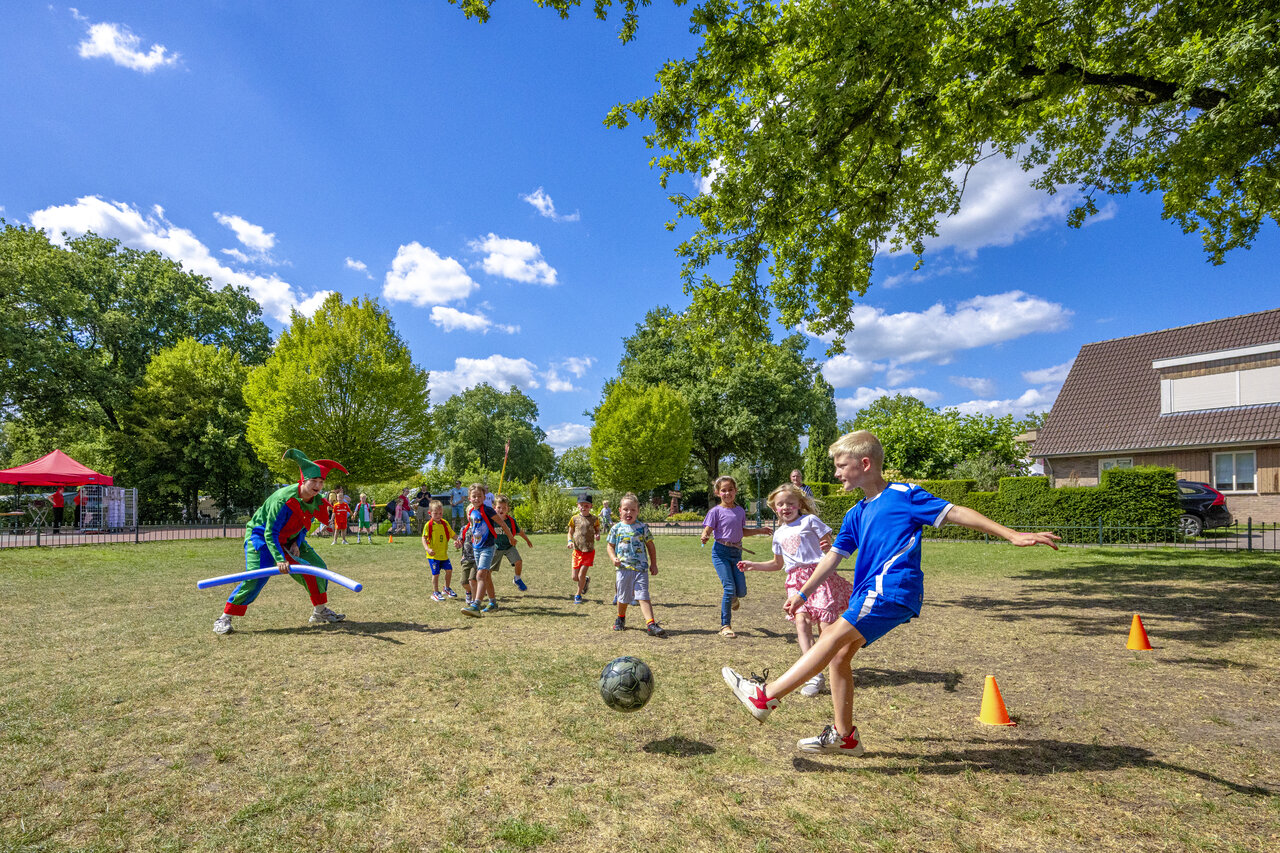 Kinderen voetballen met verklede animator op camping CAPFUN De Sprookjescamping in Rheeze.