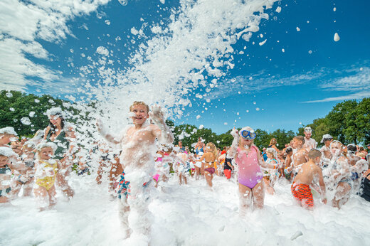 Kinderen en volwassenen genieten van een schuimfeest op camping CAPFUN De Sprookjescamping in Rheeze.