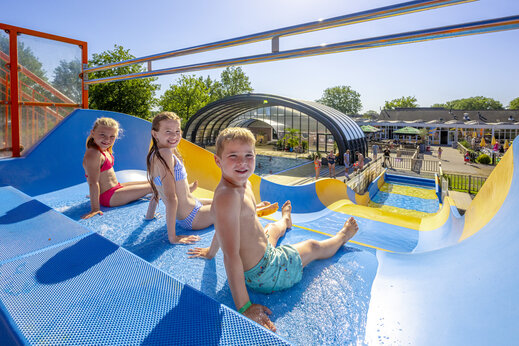 Reuzenglijbaan en lachende kinderen op camping CAPFUN De Sprookjescamping in Rheeze.