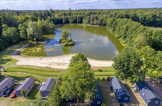 Luchtfoto meer, zandstrand en stacaravans op camping CAPFUN De Sprookjescamping in Rheeze.