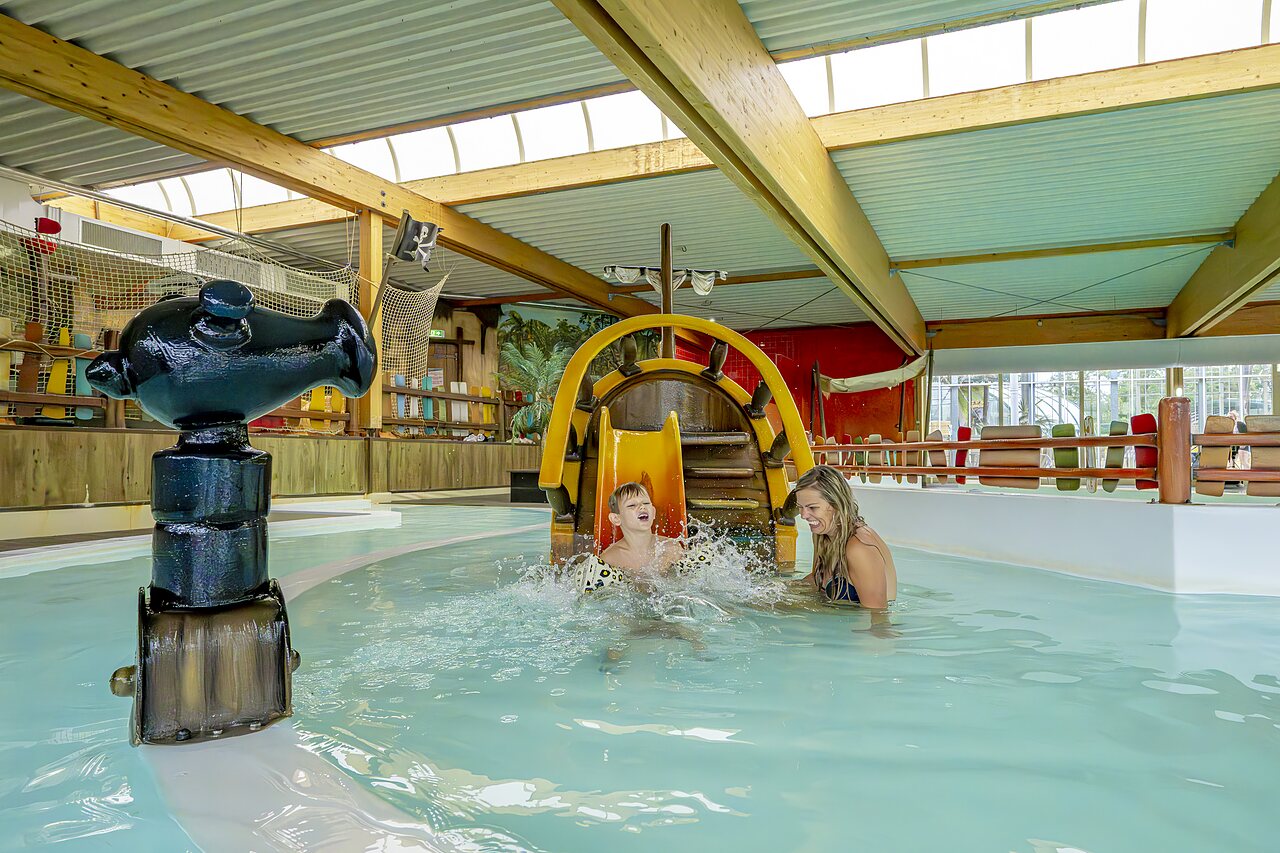 Kind en vrouw lachend op piratenwaterglijbaan in binnenzwembad op camping CAPFUN Vakantiepark Capfun het Stoetenslagh in Rheezerveen.