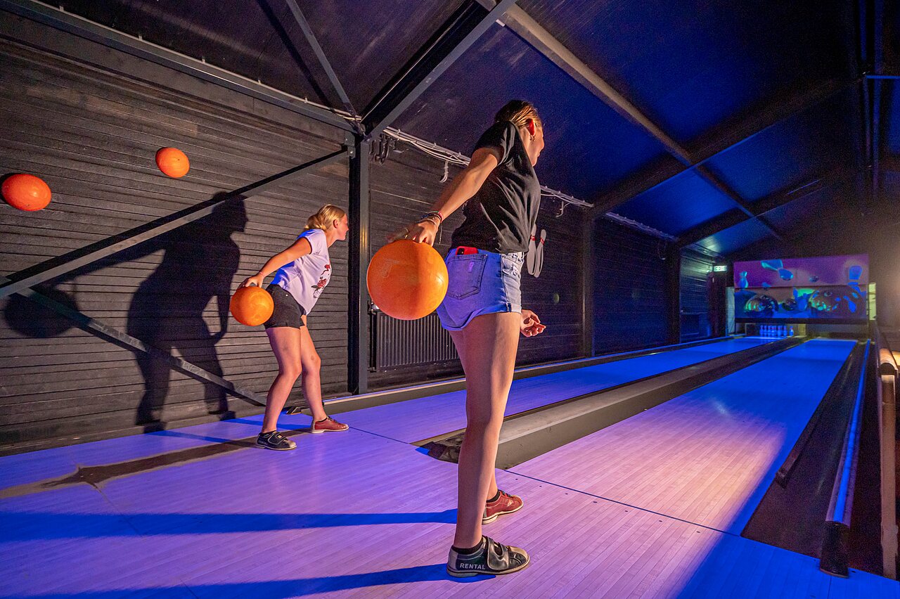 Jongeren bowlen op verlichte banen op camping CAPFUN Vakantiepark het Stoetenslagh in Rheezerveen.
