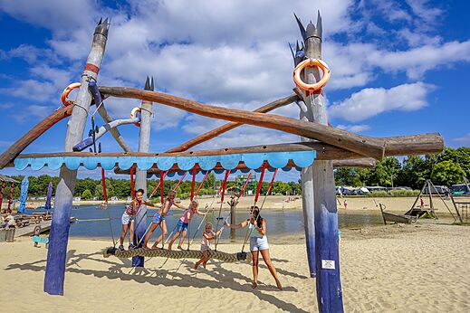 Houten speelstructuur op het strand bij camping CAPFUN Vakantiepark Capfun het Stoetenslagh à Rheezerveen.