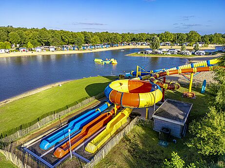 Grote waterglijbanen en zandstrand aan het meer bij CAPFUN Vakantiepark Capfun het Stoetenslagh.