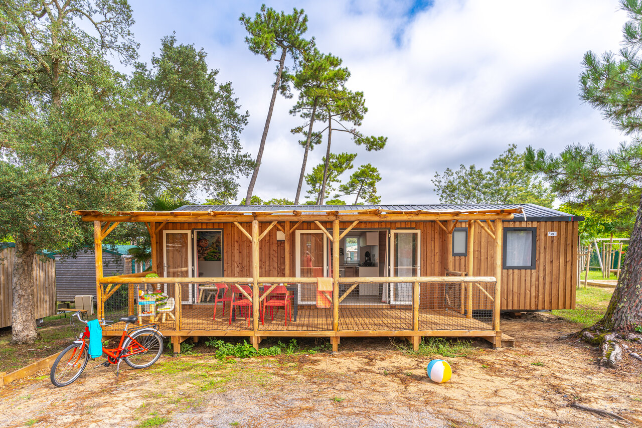 Houten stacaravan met terras, fiets, natuurlijke sfeer op camping CAPFUN Sud Land.