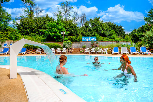 Buitenzwembad met waterval op camping CAPFUN Suzel in Sainte-Croix-en-Plaine (68).