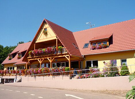 Bloemrijke hoofdreceptie met balkon op camping CAPFUN Suzel in Sainte-Croix-en-Plaine (68).
