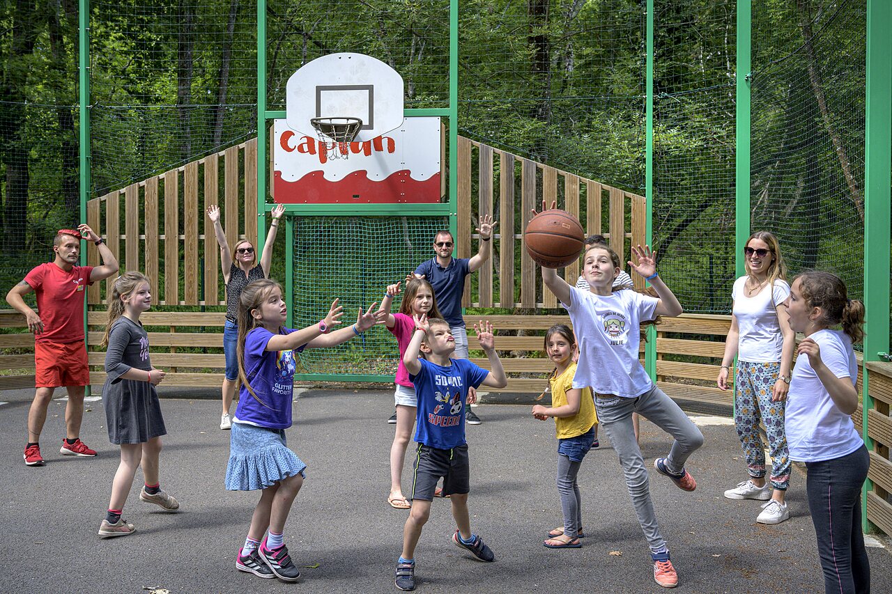 Basketbalveld met kinderen en volwassenen spelend op camping CAPFUN Talaris Vacances in Lacanau (33).