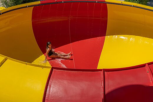 Meisje glijdt van rode en gele waterglijbaan op CAPFUN Talaris Vacances in Lacanau (33).
