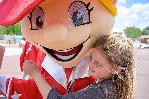 Kind knuffelt de mascotte van camping CAPFUN Talaris Vacances in Lacanau (33).