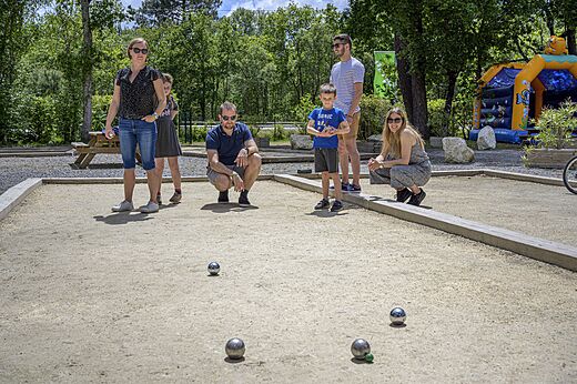 Familie speelt jeu de boules op het terrein van camping CAPFUN Talaris Vacances.