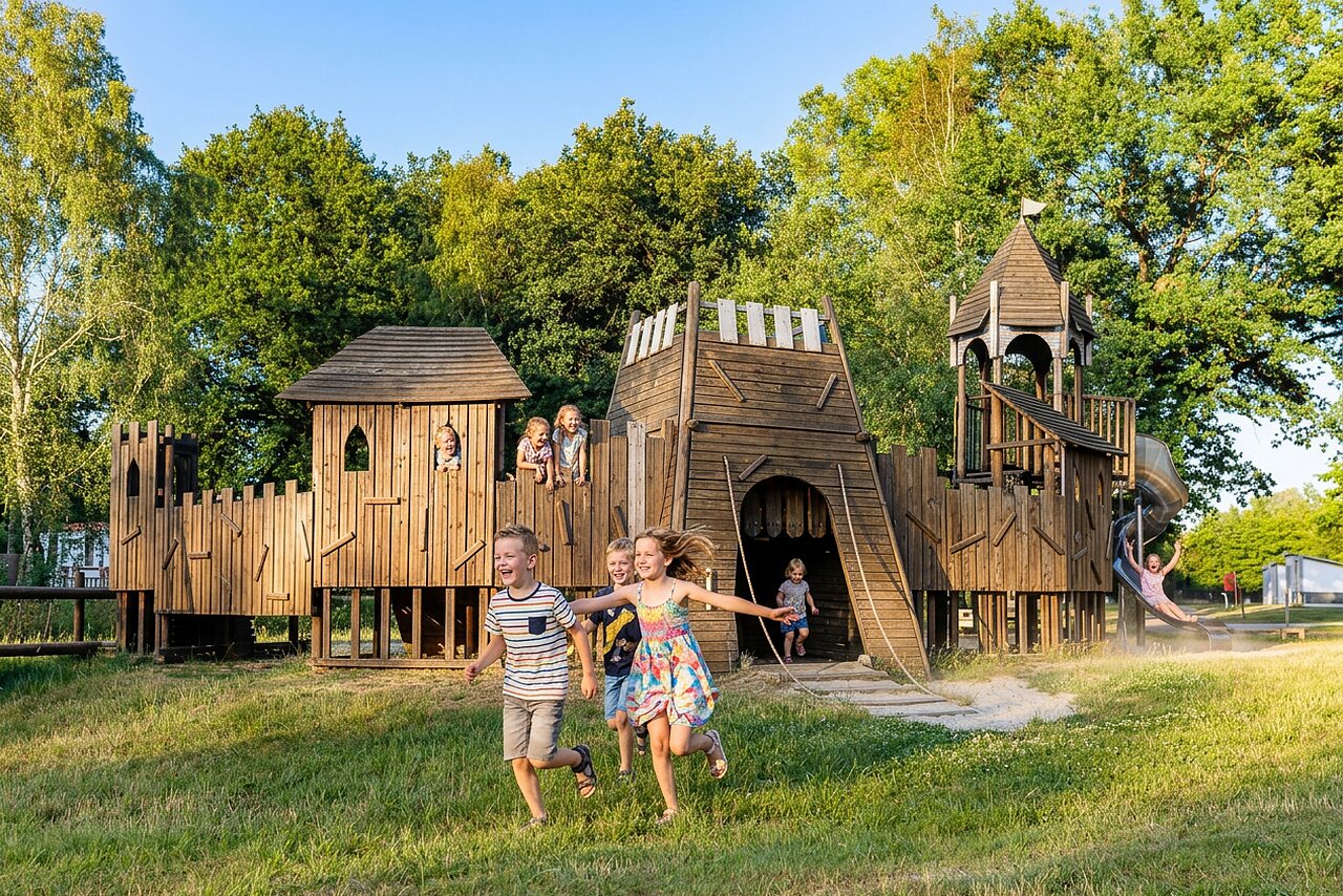 Kinderen spelen op houten kasteel speeltuin bij camping CAPFUN Tecklenburg (49).