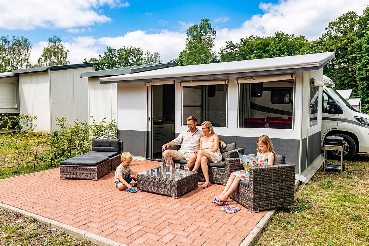 Ontspannen familie op het terras van een stacaravan op camping CAPFUN Tecklenburg in Tecklenburg-Leeden (49).