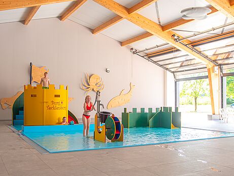 Speels binnenzwembad, waterspelen op camping CAPFUN Tecklenburg in Tecklenburg-Leeden.