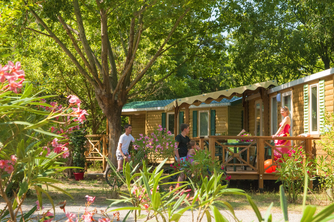 Houten Mobil-home met terras en familie op camping CAPFUN Temps Libre in BOUGE CHAMBALUD (38).