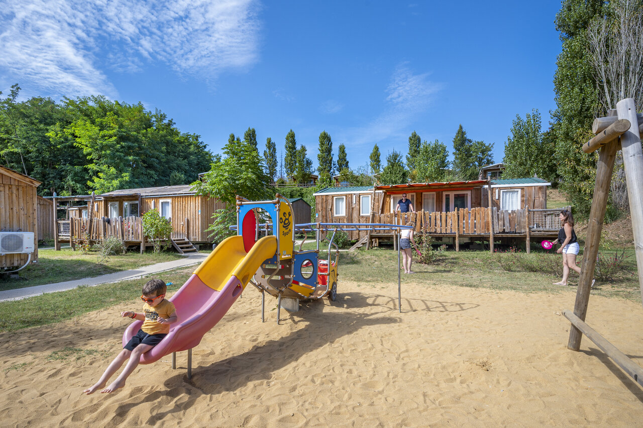 Speeltuin met glijbaan en stacaravans op camping CAPFUN Temps Libre in BOUGE CHAMBALUD (38).