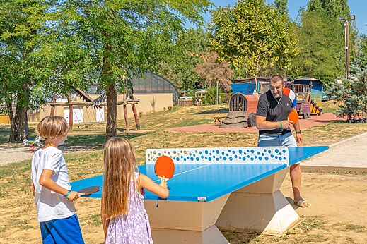 Familie speelt buiten tafeltennis op camping CAPFUN Temps Libre in BOUGE CHAMBALUD.
