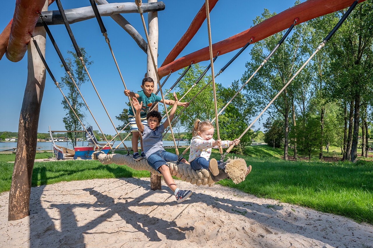 Kinderen spelen op grote touwschommel op camping CAPFUN Tensch Jolie in Grostenquin (57).