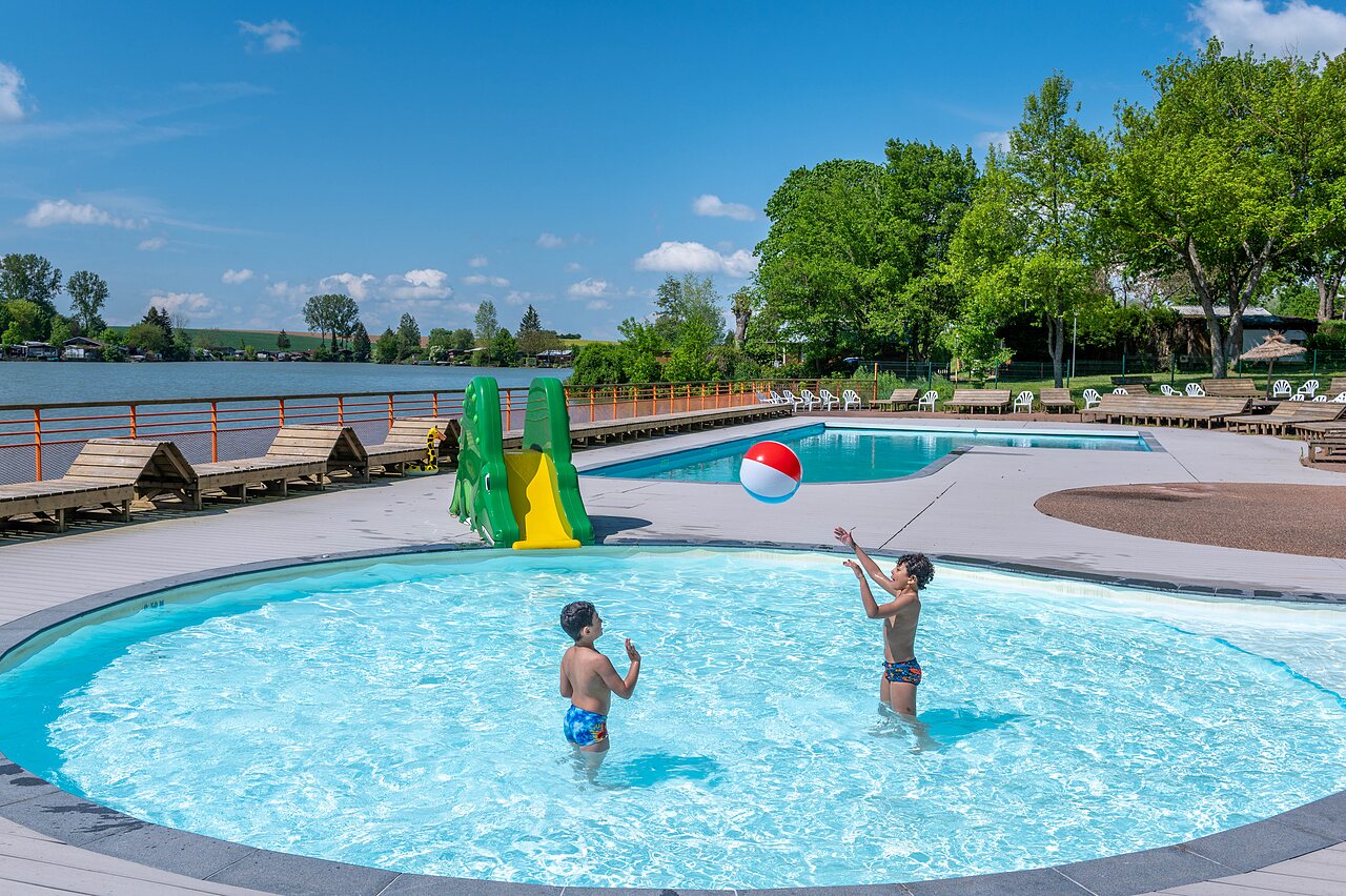 Buitenzwembad, glijbaan en spelende kinderen op camping CAPFUN Tensch Jolie in Grostenquin (57).