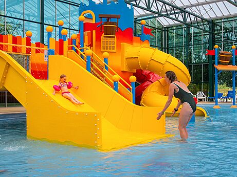 Kleurrijke waterglijbanen en waterspellen in het zwembad van camping CAPFUN Tensch Jolie.