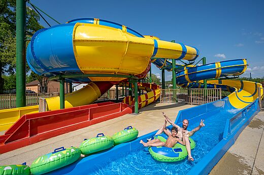 Kleurrijke waterglijbanen met vader en zoon op camping CAPFUN Tensch Jolie in Grostenquin (57).