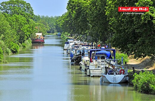 Canal du Midi, historische waterweg met bomen en aangemeerde woonboten.
