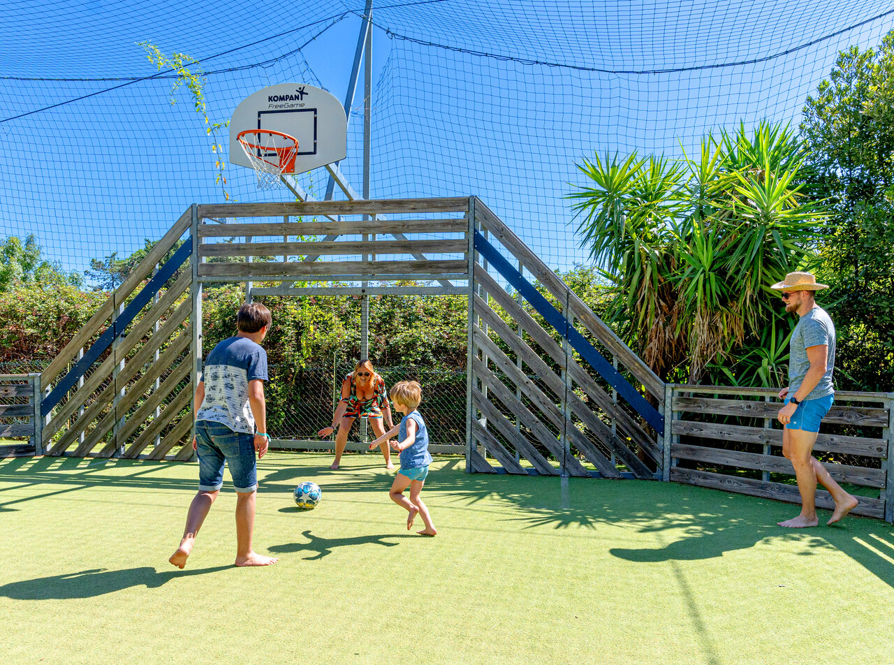 Familie speelt voetbal op multisportterrein op camping CLICOCHIC Texas, Argel�s.