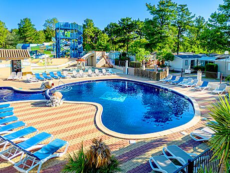 Buitenzwembad met waterglijbanen en stoelen op camping CLICOCHIC Texas in Argelès sur Mer (66).