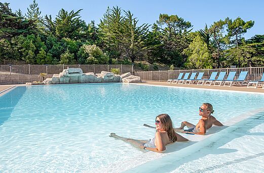 Buitenzwembad met waterval op camping CLICOCHIC Plage des Tonnelles.
