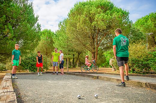 Familie speelt jeu de boules op het speelterrein van camping CLICOCHIC Plage des Tonnelles in Saint-Jean-de-Monts (85).