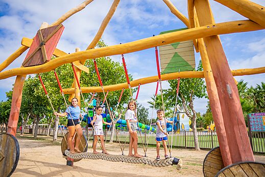 Kinderen spelen op houten speeltoestel op camping CAPFUN Tordera-Nacions in Malgrat de Mar (08).