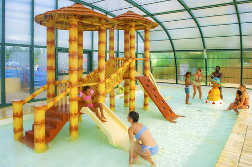 Overdekt waterpark met speeltoestellen en glijbanen op camping CAPFUN Celeste in Breuillet (17).