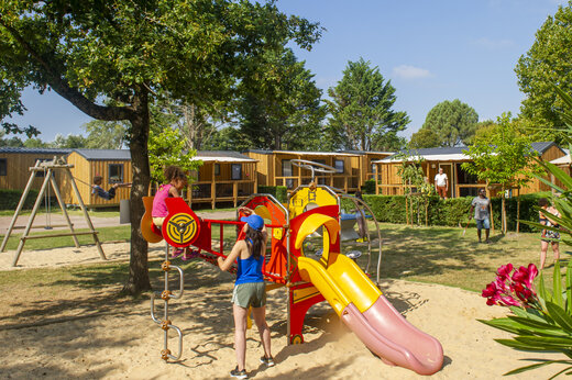 Kinderspeeltuin met glijbaan en Mobil-homes op camping CAPFUN Celeste in Breuillet (17).