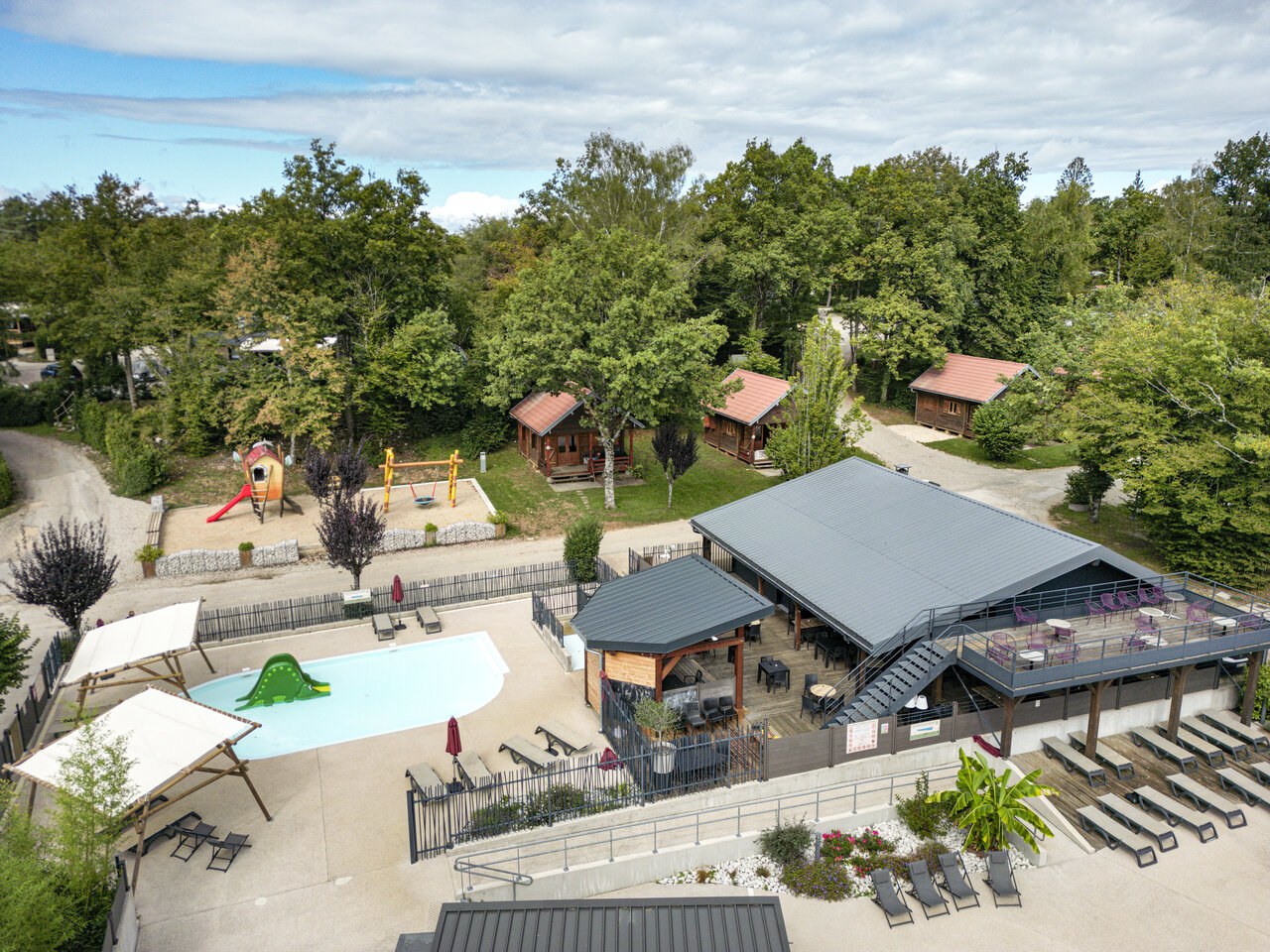 Luchtfoto zwembad, restaurant en stacaravans op camping CLICOCHIC Trelachaume in Maisod (39).