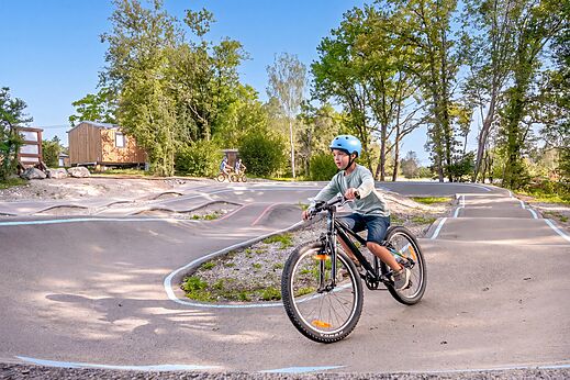 Kind op fiets op de pumptrackbaan bij camping CLICOCHIC Trelachaume in Maisod (39).