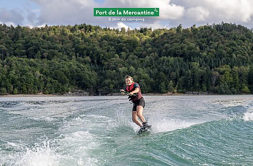 Jonge vrouw wakeboardend op het meer bij Port de la Mercantine, Jura.