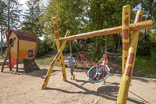 Speeltuin met nestschommel en speelhuisje, camping CLICOCHIC Trelachaume in Maisod (39).