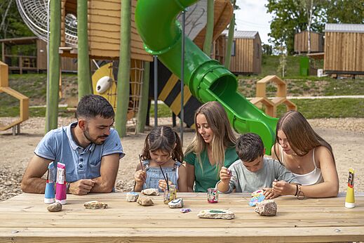 Familie schildert stenen, speeltuin op camping CLICOCHIC Trelachaume in Maisod (39).