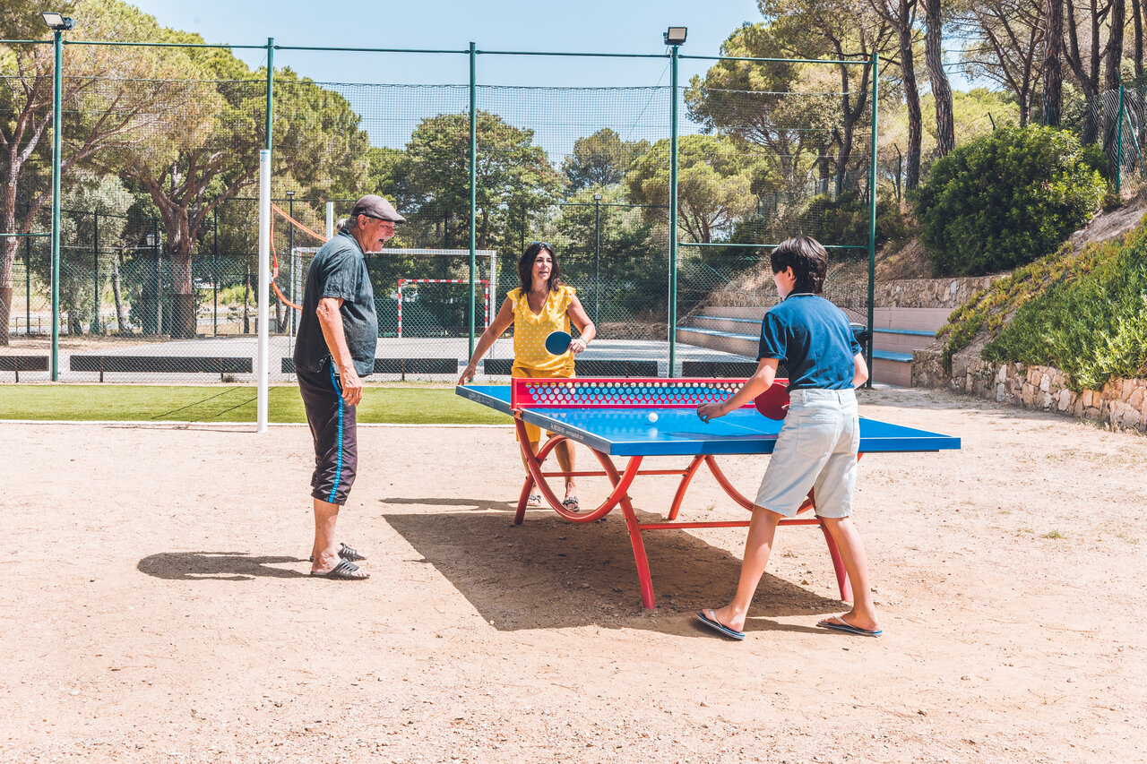 Familie speelt tafeltennis buiten op camping CAPFUN Treumal in Platja d'Aro.