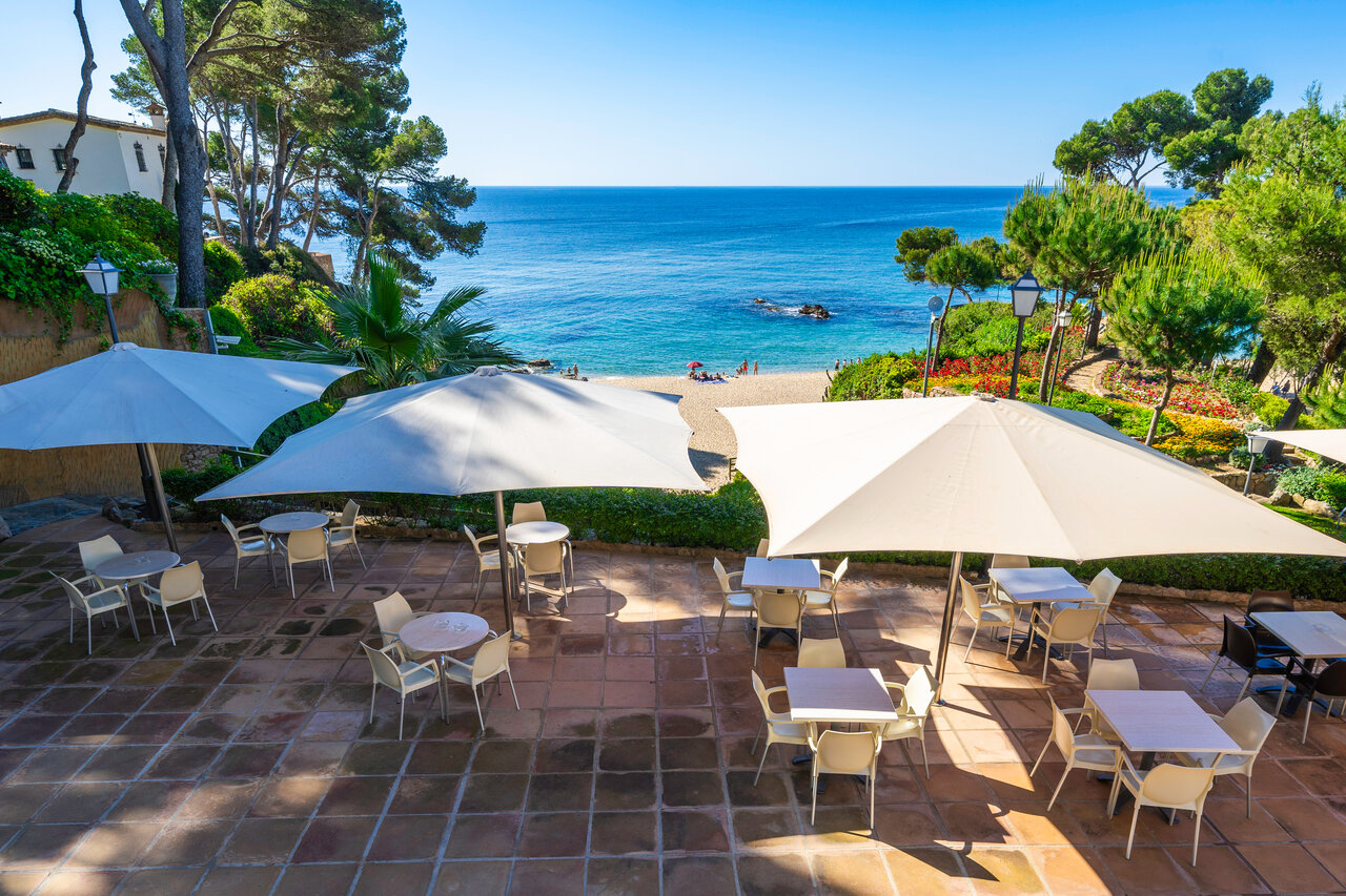 Restaurantterras met parasols, strand en Middellandse Zee op camping CAPFUN Treumal in Platja d'Aro (17).